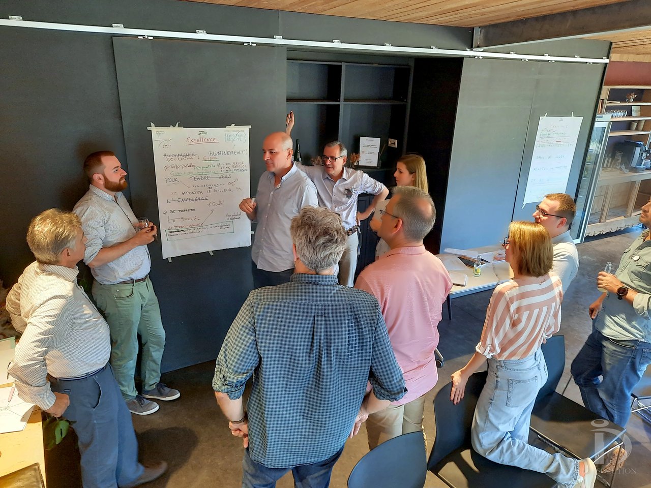 Petits groupes debout devant les paperboards, en pleine construction collective