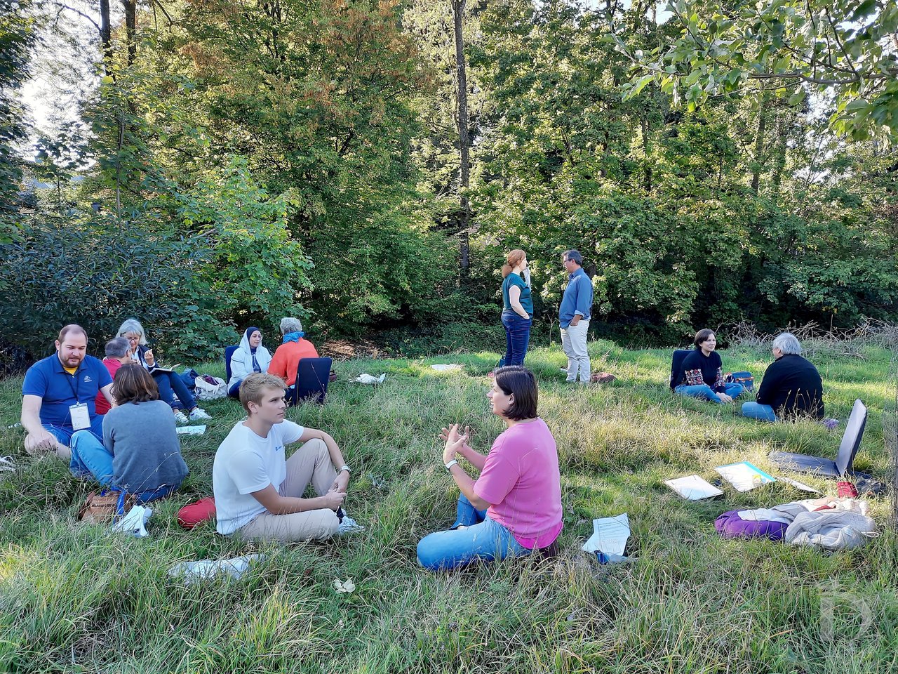 Ateliers en binômes dans une clairière, assis dans l'herbe