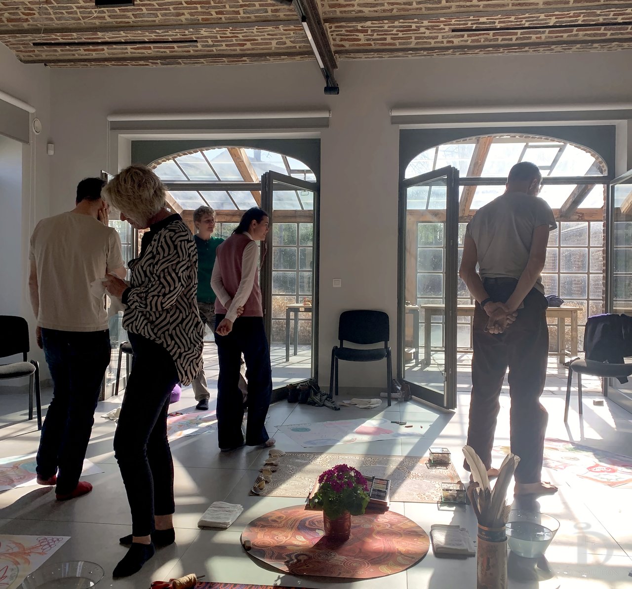 Séance Révélation : les participants debout, en écoute, dans la salle en brique